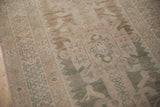 Faded texture of a distressed Hamadan runner showing even wear, abrashed beige and green tones.