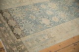 Distressed Bijar rug runner detail: worn knot heads, faded blue floral guls, and beige geometric border.