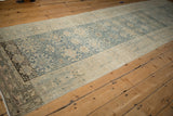 Distressed vintage Bijar runner corner detail, pale blue and ivory geometric border, showing even wear.