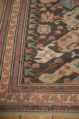 Angled detail of antique Soumac runner, red border, chocolate field dragon arabesques.