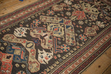 Antique Soumac runner close-up: chocolate field with red, blue, beige geometric floral motifs.