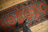 Antique Northwest Persian runner featuring sprawling finned leaves, red field, and serrated border.