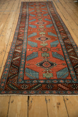 Antique Northwest Persian runner's red field, sprawling sky blue finned leaves, and serrated border.