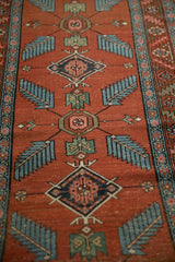 Antique Northwest Persian runner's red field with sprawling sky blue finned leaves and floral diamond motifs.