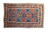 Antique Caucasian carpet, madder root red and sapphire blue zig zag diamond medallions.