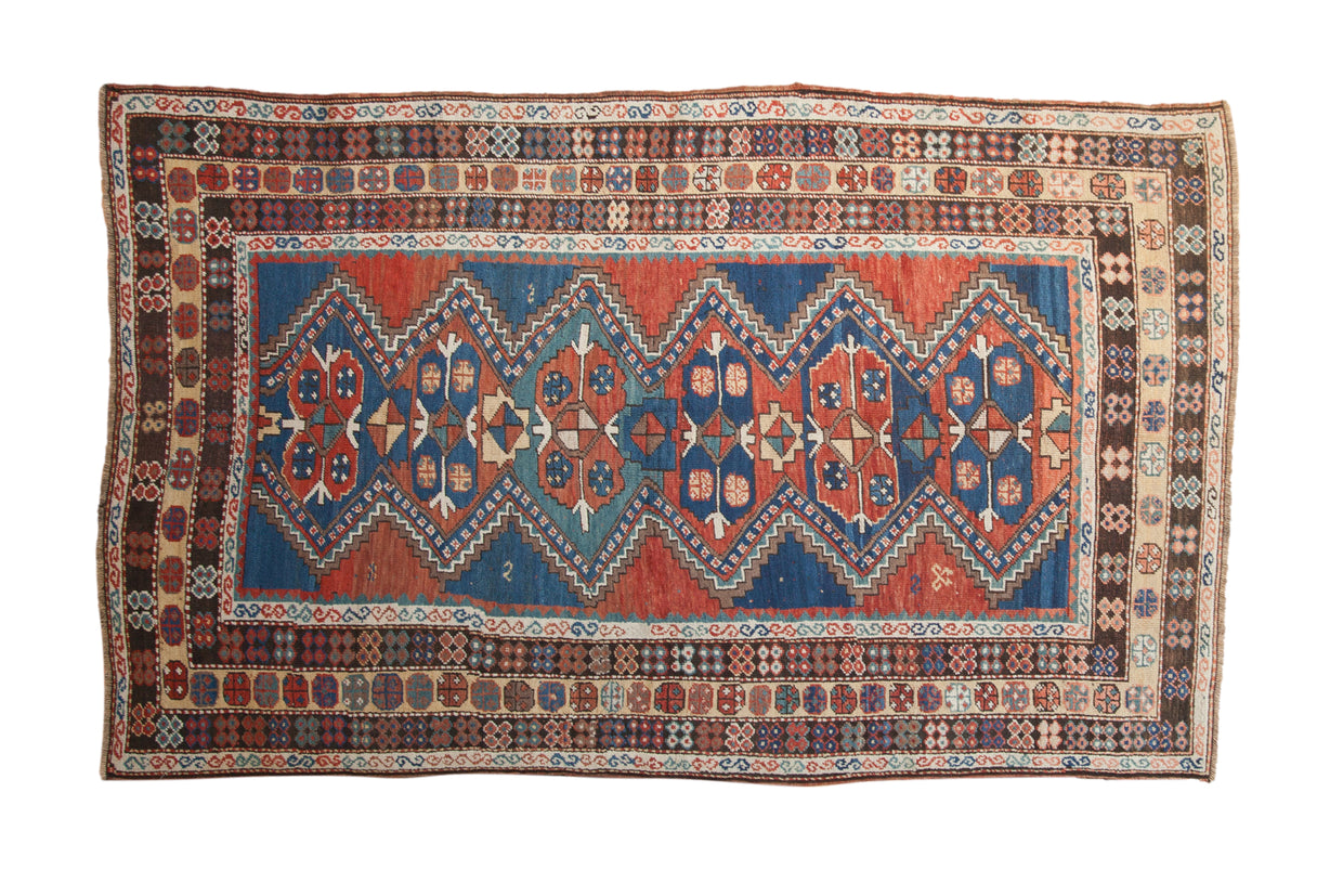 Antique Caucasian carpet, madder root red and sapphire blue zig zag diamond medallions.