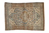 Distressed Persian Dargezine rug with indigo medallion, beige ground, flowing vines.