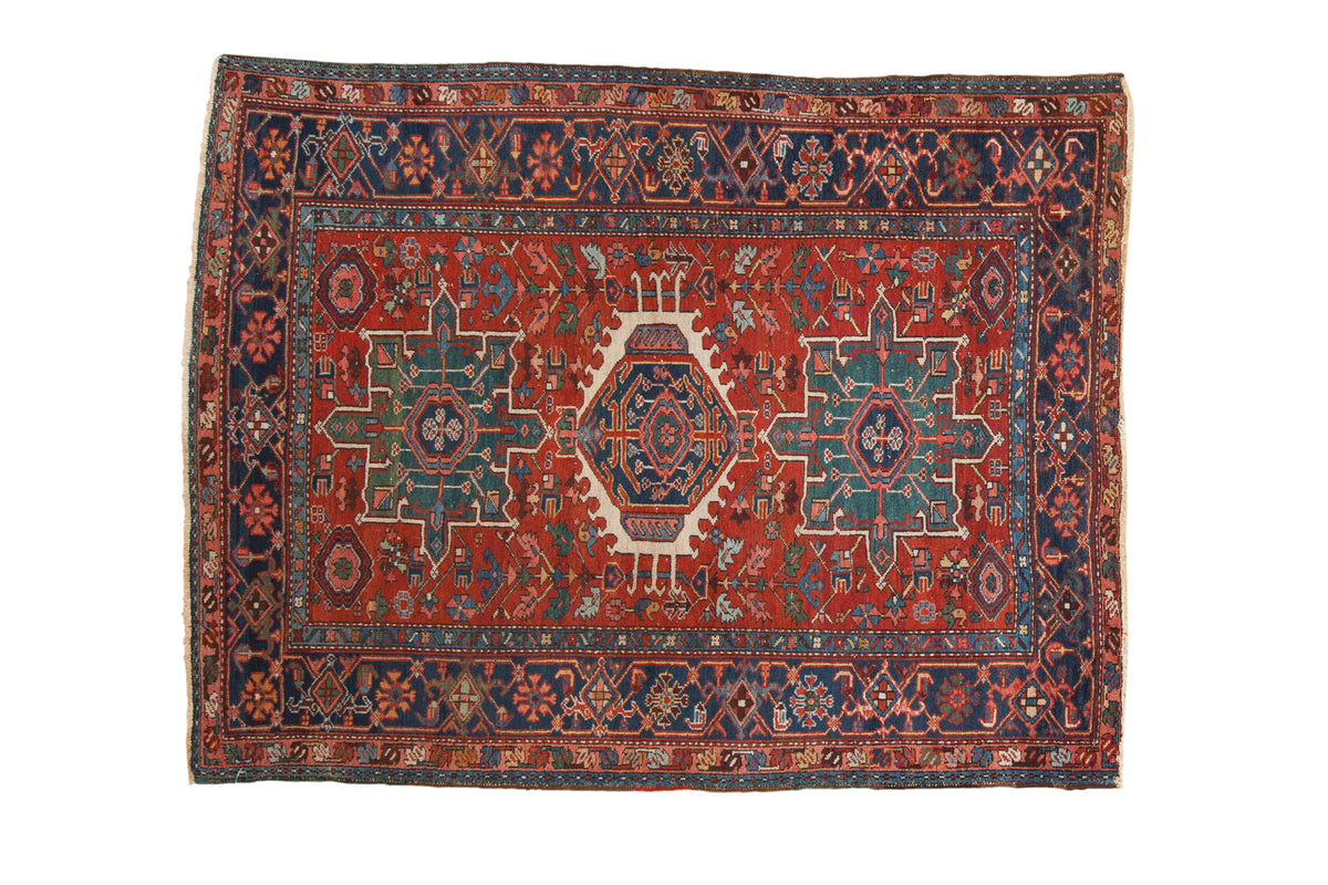 Hand-knotted vintage Karaja rug, brick red field, navy medallion, geometric florals, Herati border.