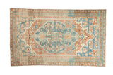 Distressed Persian Bakhtiari rug, bold medallion, floral patterns, in sky blue, coral, and beige.