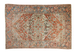Distressed Vintage Bakhtiari rug, starburst medallion, botanical patterns in faded red, blue, beige.
