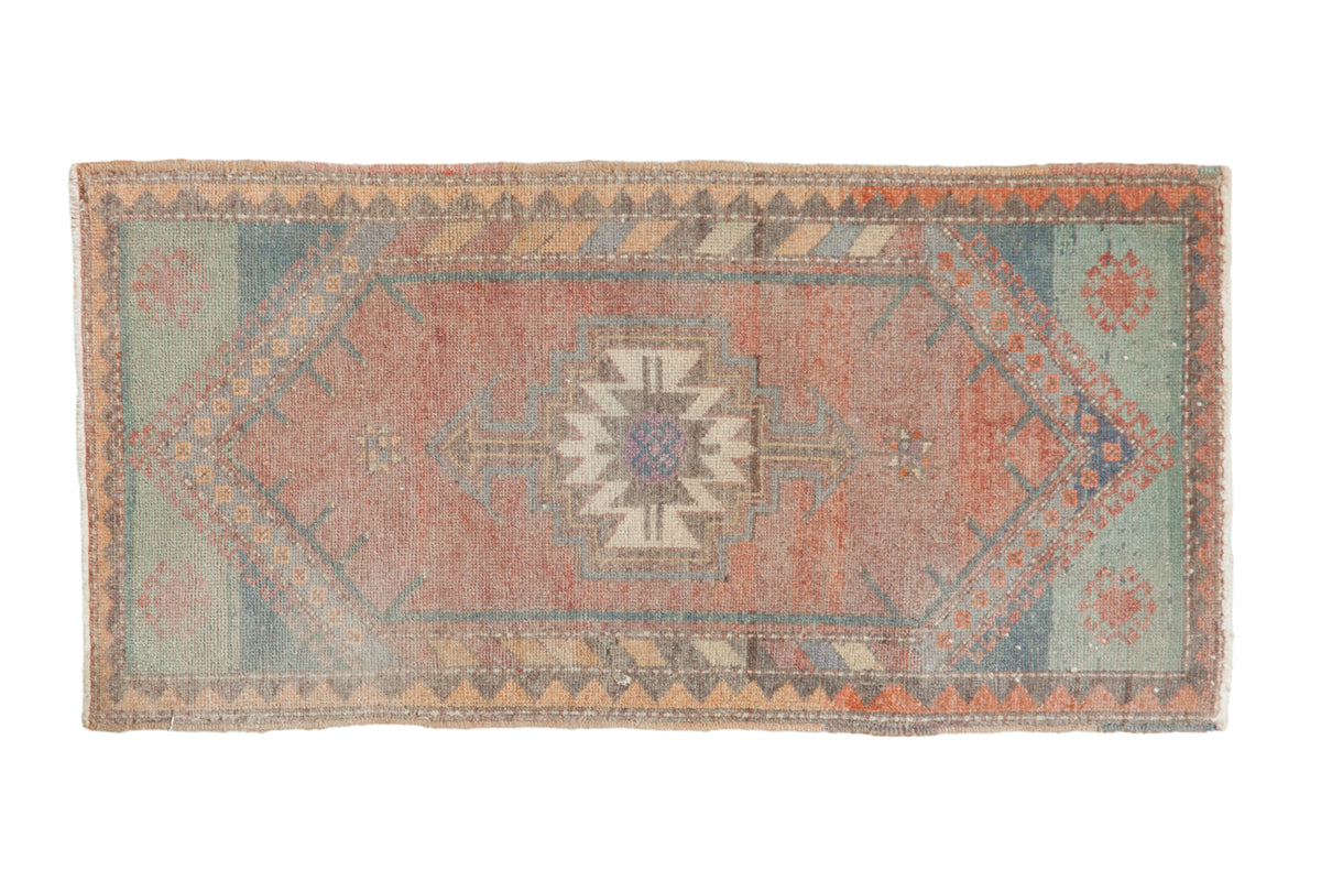 Distressed vintage Oushak rug mat with a serrated medallion in faded dusty red, blue, and tangerine.