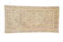 Distressed Oushak rug mat with a soft beige medallion and faded patterns.