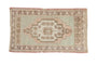 Vintage distressed Oushak rug mat displaying a stepped medallion and soft pastel hues.