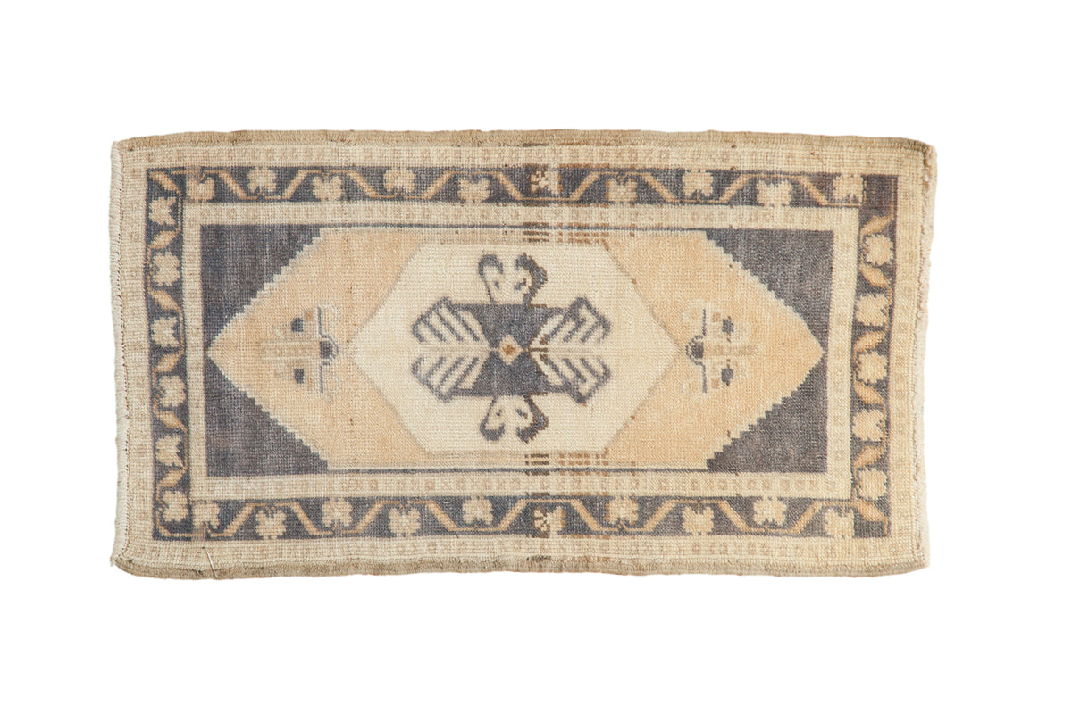 Distressed Oushak rug mat with faded navy blue medallion, cream, ivory, and beige motifs.