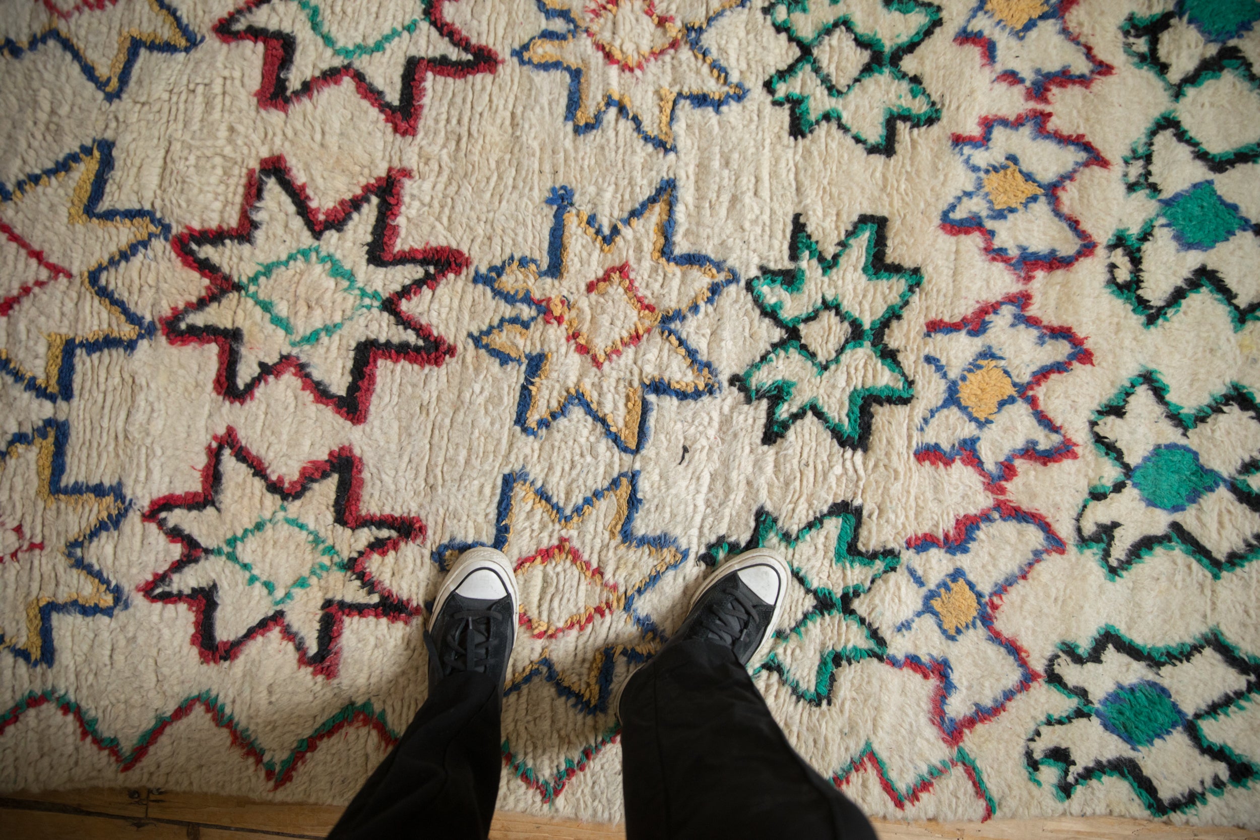 Textured wool pile of the vintage Moroccan runner with abstract starburst motifs.