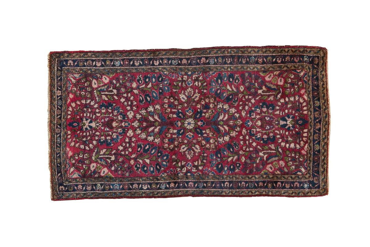 Vintage Sarouk runner, cherry red field, all-over sapphire blue floral bouquet, triple border.