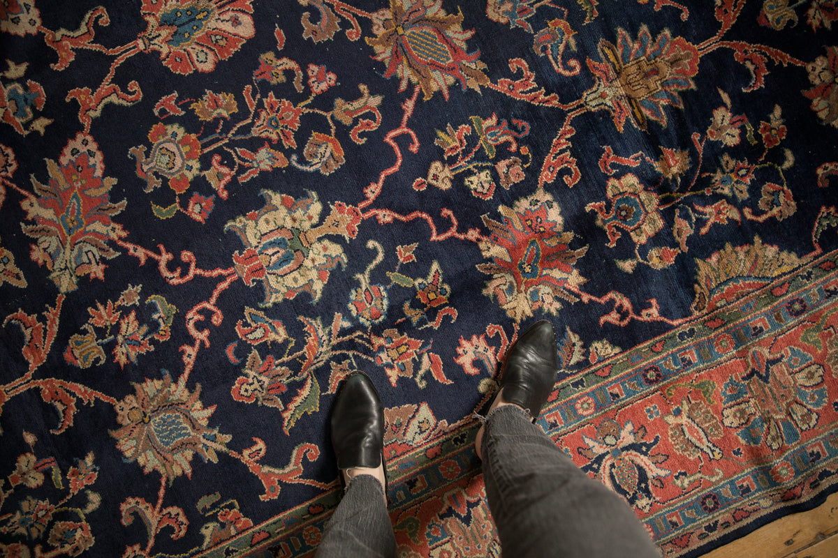 Dark navy vintage Lilihan carpet with madder root palmettes, blue tendrils, and visible, soft pile texture.