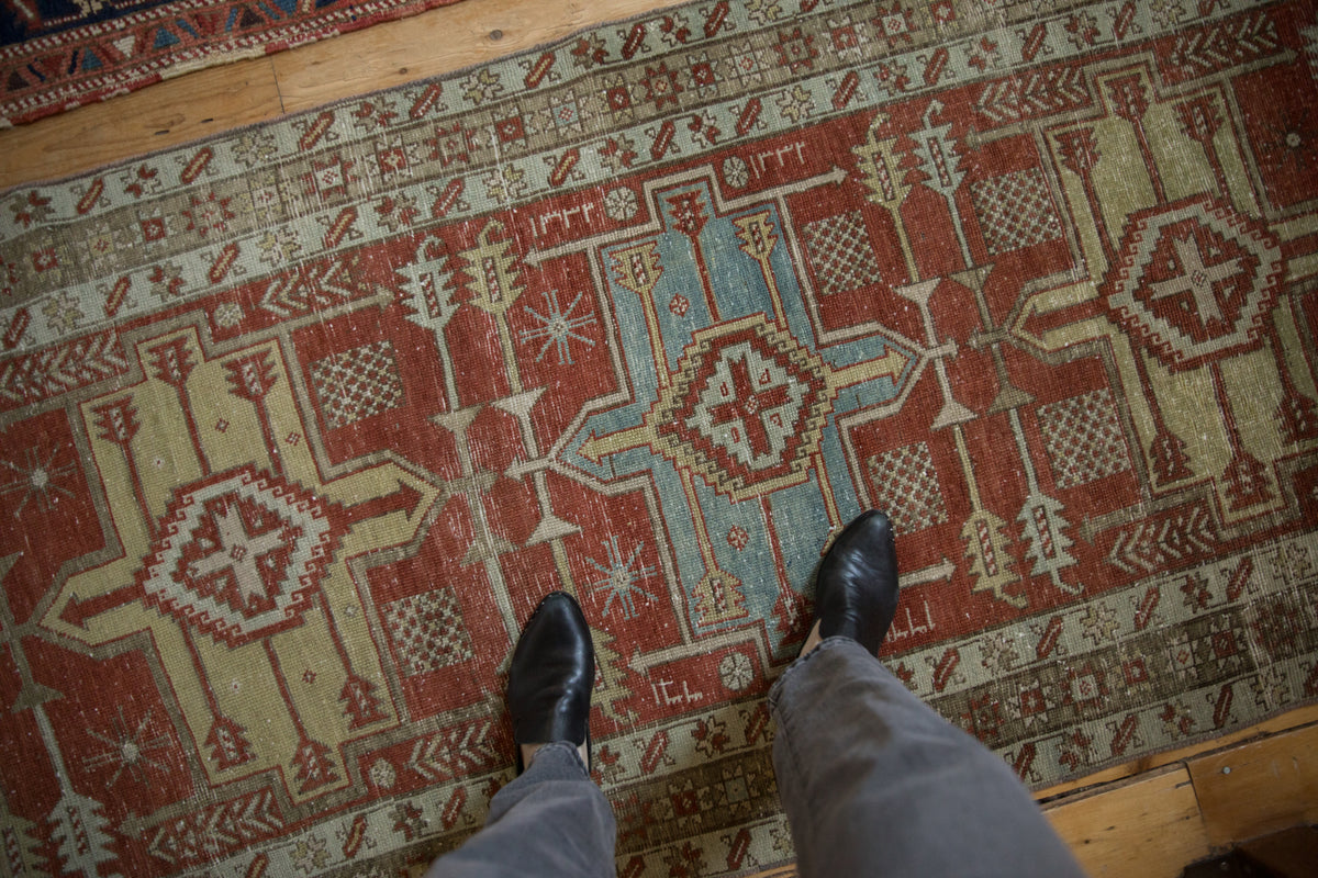 Distressed Karaja runner with geometric medallions in madder red and sky blue tones.