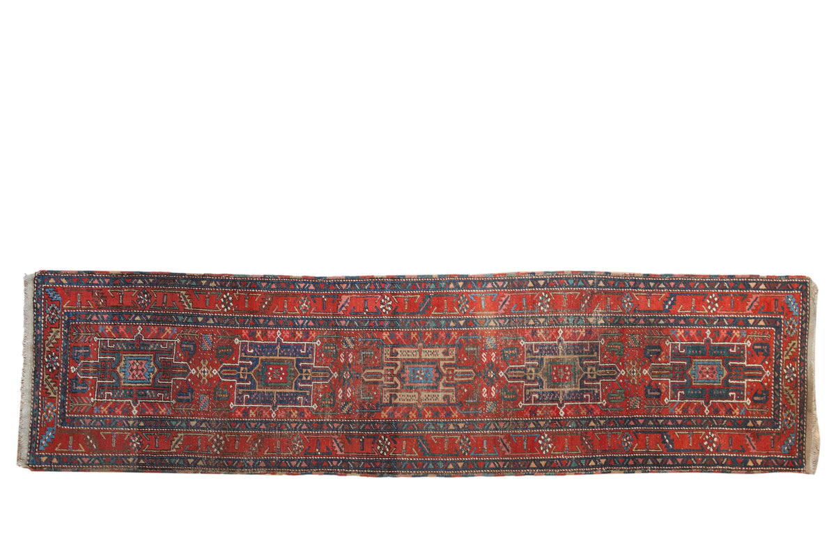 Vintage Persian Heriz runner with Karaja geometric medallions, guls, ruby red, and sapphire blue.