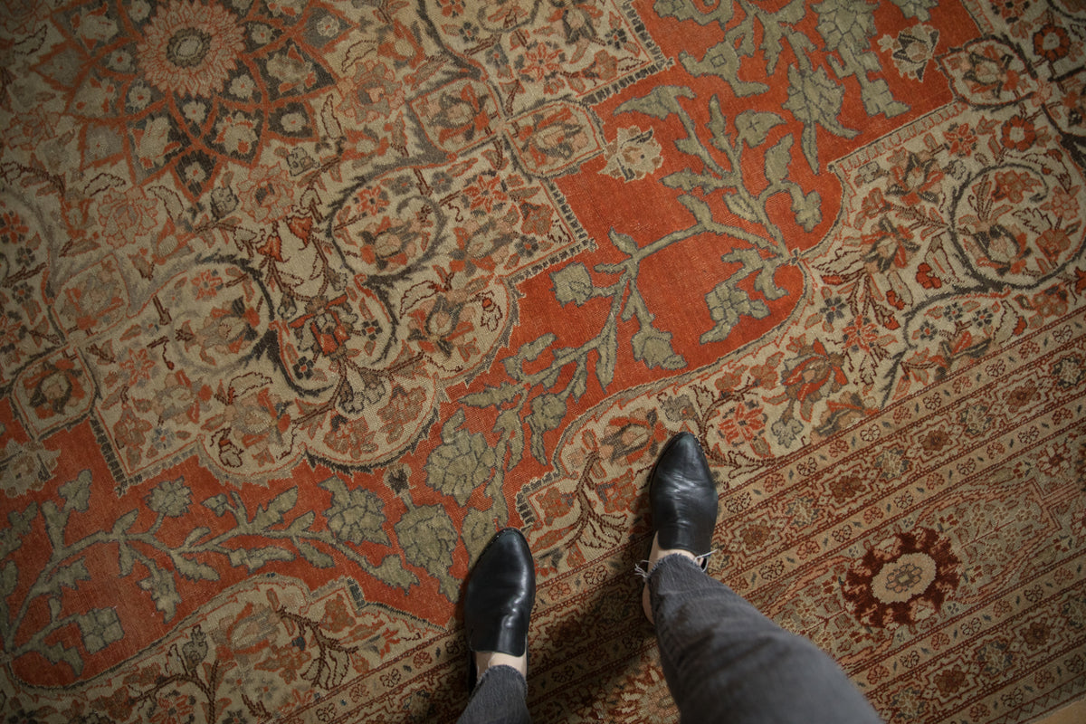 Vintage Tabriz carpet's rust and ivory field with expressive floral renderings.