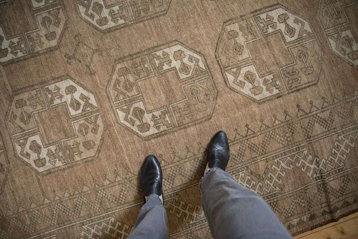 Distressed vintage Ersari rug, octagonal guls and worn pile in beige and platinum tones.