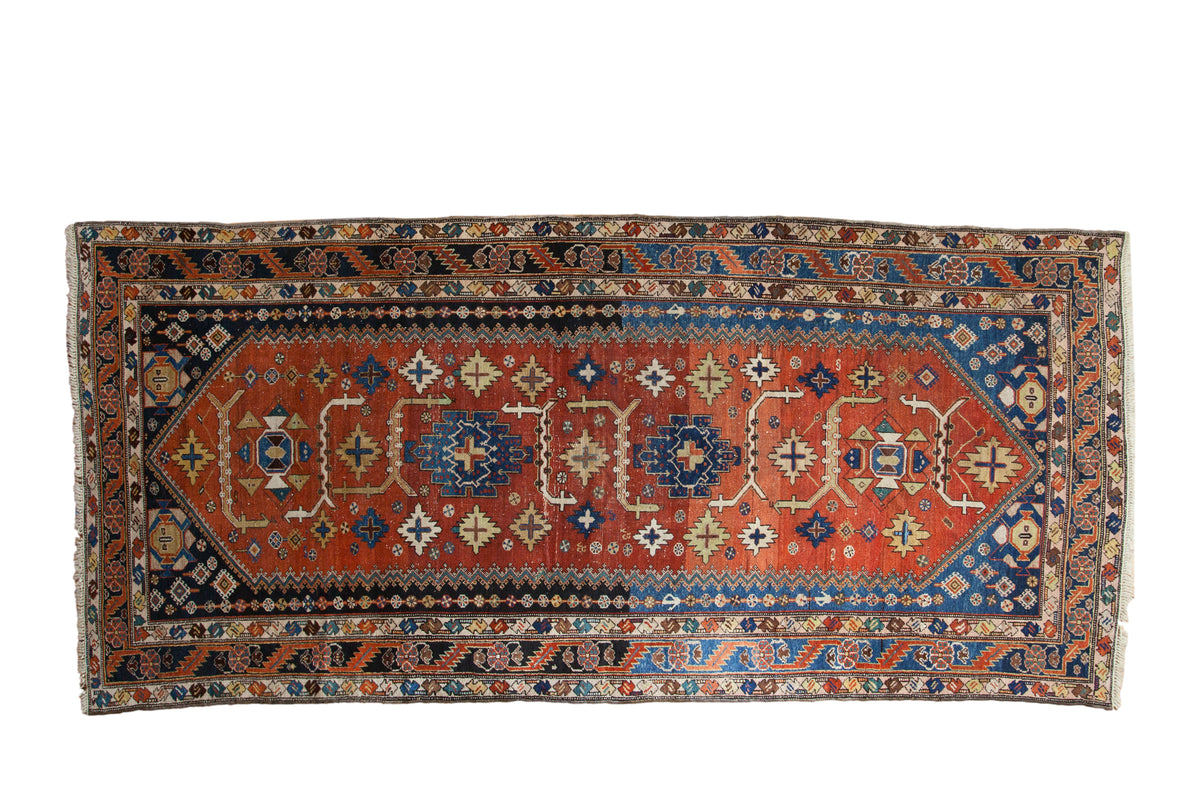 Antique Persian Mehraban runner, madder red and navy field featuring geometric floral motifs.