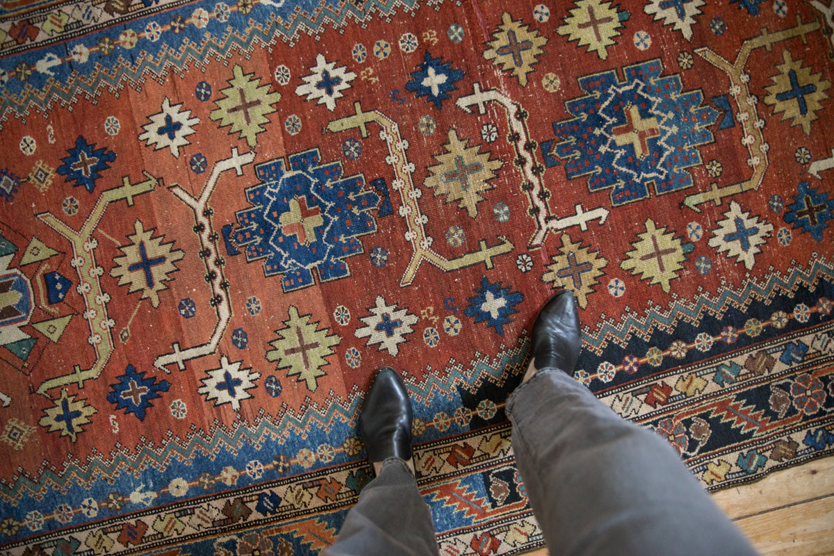 Antique Mehraban rug with madder red field, angular navy, green geometric motifs, and soft wear.