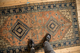 Hand-knotted Northwest Persian runner corner with navy blue pinwheel border, terracotta field.