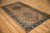 Vintage Northwest Persian runner corner with terracotta field and navy pinwheel floral border.