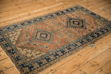 Navy blue pinwheel main border, geometric beige minor border, terracotta field with wear.