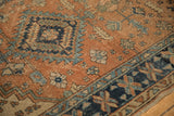 Vintage Heriz-area rug detail: terracotta field, pinwheel, and geometric vine borders.
