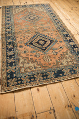 Heriz-area vintage runner corner; navy, terracotta pinwheel and vine border patterns.
