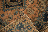 Folded corner of vintage Persian rug, revealing geometric patterns, worn pile, and hand-knotted foundation.