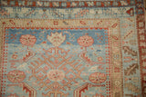 Distressed vintage Persian runner corner, abrash blue field with Herati motifs, red serrated border.