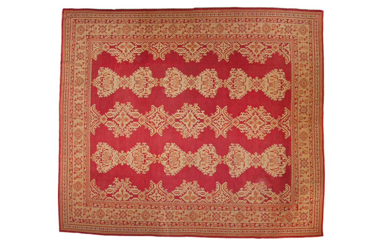 Vintage Oushak carpet, deep red field with linked golden geometric medallions, layered patterned borders.