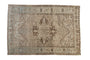 Distressed vintage Persian Heriz carpet, geometric starburst medallion, muted neutrals and faded teal.