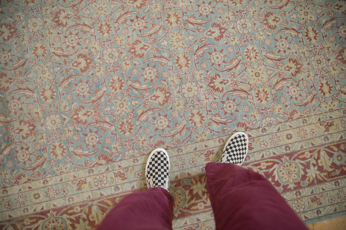 Distressed vintage Tabriz carpet featuring all-over Herati floral motif and detailed border.