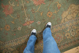Close view of the Soumac carpet's flat weave and Serapi-inspired pattern in seafoam green and terracotta.