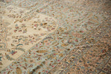 Ornate floral bouquets and scrolling vinery on the plush pile of a vintage Kerman design carpet.