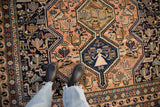 Vintage Ardebil carpet detail: inverted peach and navy field with stylized birds, animals, and people.