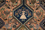 Vintage Ardebil carpet detail: stylized ivory person, animals, and bird motifs on navy and peach fields.