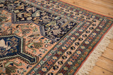 Hand-knotted Ardebil carpet pattern of stylized birds, animals, and pinwheels in peach, navy, and green with fringe.