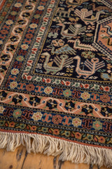 Robust ivory fringe, pale peach border, and navy blue field with stylized birds on the Ardebil carpet.