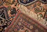 Hand-knotted reverse, detailed border, and cream fringe of a vintage Ardebil rug corner.