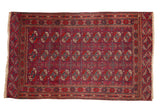 Vintage Tekke rug with repeating geometric gul motifs in burgundy wine red and dusty navy blue.