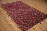 Angled view of a vintage Tekke rug, showing the intricate geometric gul pattern in burgundy and navy.