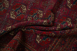 Draped view highlighting the intricate geometric gul design on a vintage burgundy Tekke rug.