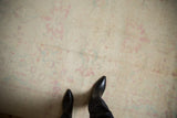 View of the distressed carpet's even, short pile with a soft antique ivory, pale raspberry, and powder blue palette.