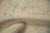 Close-up of the distressed, even pile of a vintage rug with soft raspberry and blue hues.