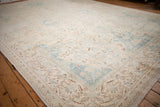 Low angle across the worn pile of a vintage Polonaise carpet in soft ivory, blue, and brown.